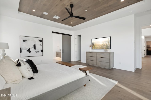 bedroom with ensuite bathroom, a tray ceiling, ceiling fan, wood-type flooring, and wooden ceiling