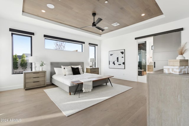 bedroom with ensuite bathroom, ceiling fan, wood ceiling, and a tray ceiling