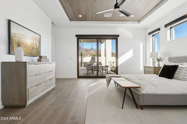 bedroom featuring a tray ceiling, access to exterior, hardwood / wood-style floors, and wood ceiling