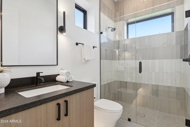 bathroom with vanity, toilet, and a shower with door