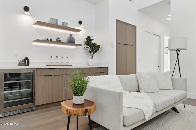 interior space featuring bar area, beverage cooler, and light wood-type flooring