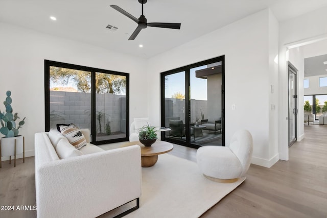 living room with ceiling fan and light wood-type flooring