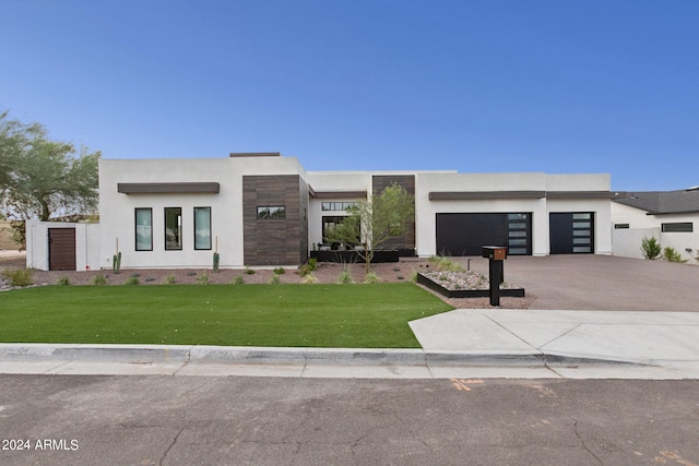 modern home featuring a garage and a front lawn