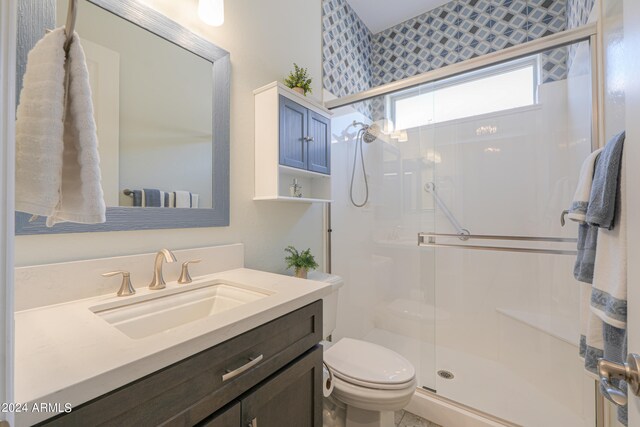 bathroom featuring vanity, toilet, and an enclosed shower