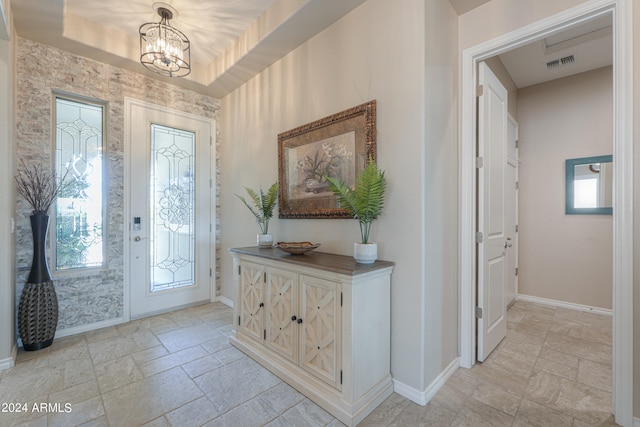 entryway featuring an inviting chandelier and plenty of natural light