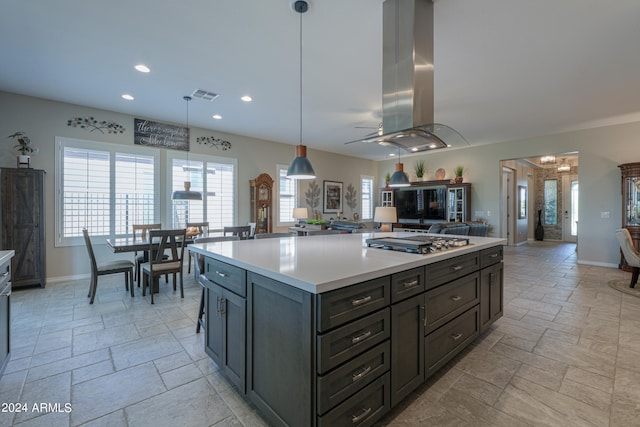 kitchen with pendant lighting, island exhaust hood, a kitchen island, and stainless steel gas cooktop