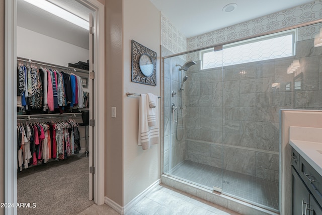 bathroom featuring tile patterned floors, a shower with shower door, and vanity