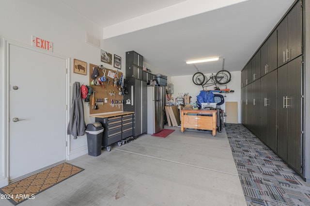 garage with stainless steel fridge and a workshop area