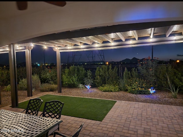 patio at twilight featuring a lawn and a pergola