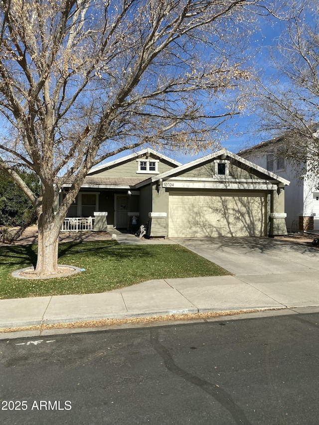 view of front of house featuring stucco siding, driveway, an attached garage, and a front yard