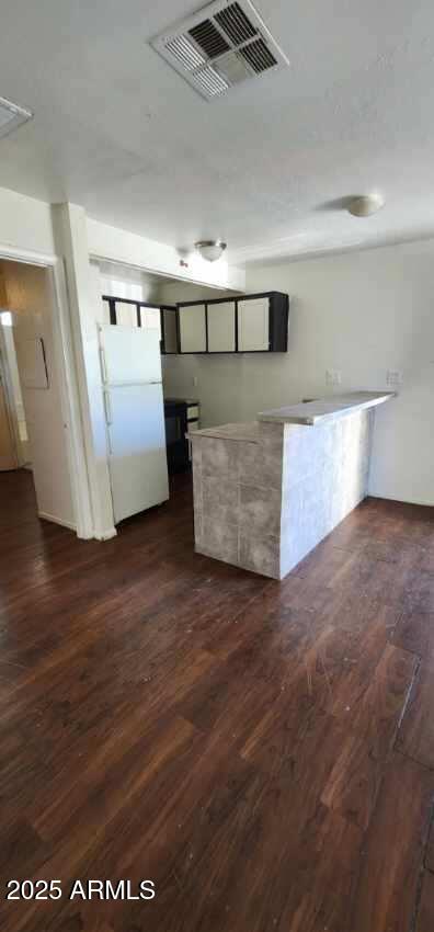 417 N 18th Dr, Phoenix, AZ 85007 - kitchen featuring freestanding refrigerator, dark wood-style flooring, and light countertops