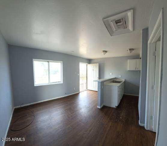 417 N 18th Dr, Phoenix, AZ 85007 - kitchen with dark wood-style floors, white cabinets, and baseboards