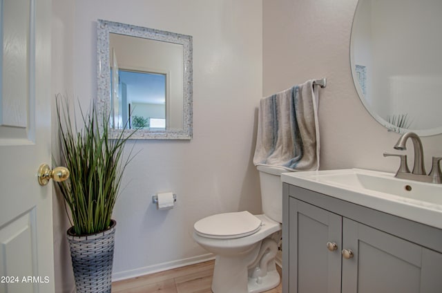 bathroom featuring vanity, hardwood / wood-style floors, and toilet