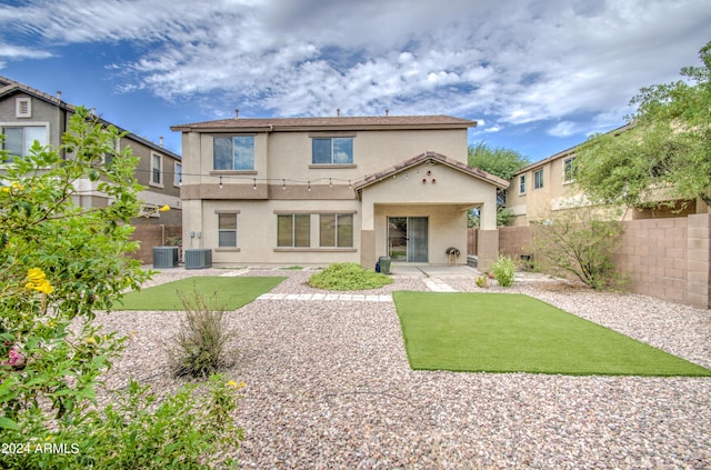 rear view of property featuring cooling unit, a yard, and a patio area