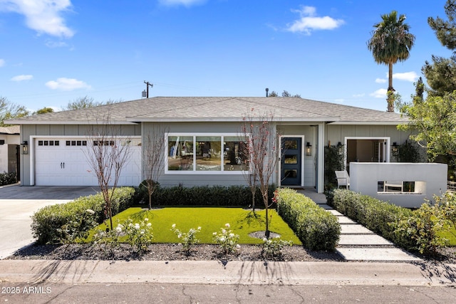 view of front facade with concrete driveway, a front lawn, and an attached garage