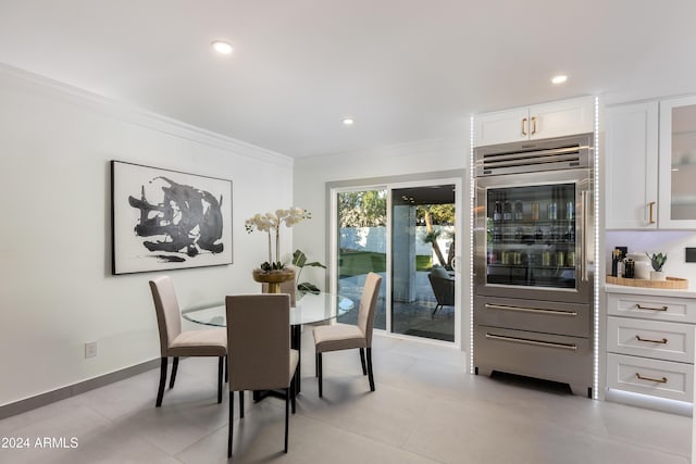 dining space with ornamental molding and light tile patterned flooring