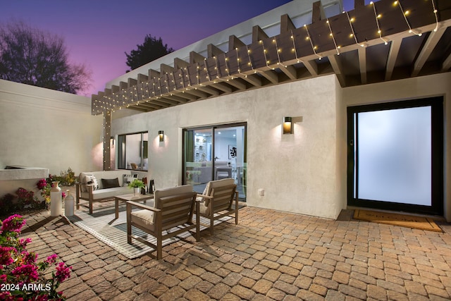 patio terrace at dusk with an outdoor living space and a balcony