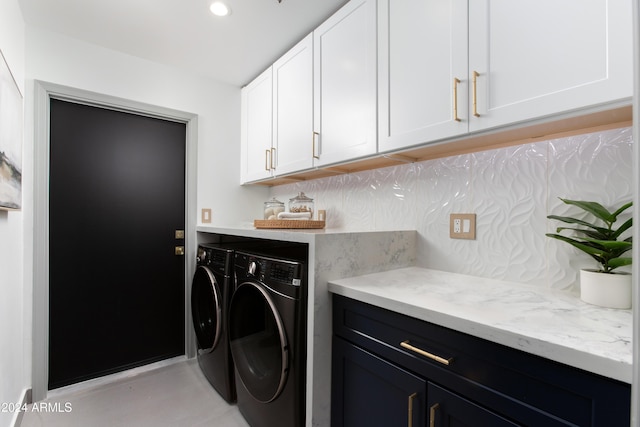 laundry area featuring washer and clothes dryer and cabinets