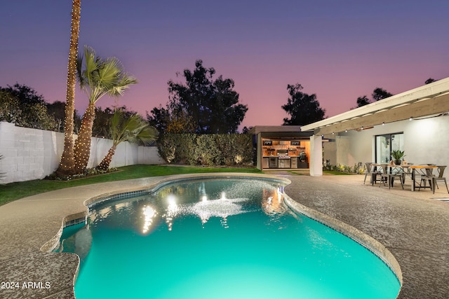 pool at dusk with a patio