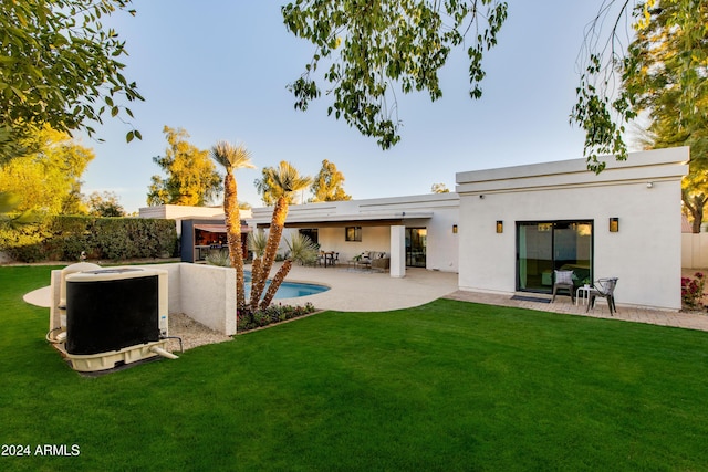 back of house with a fenced in pool, a yard, and a patio