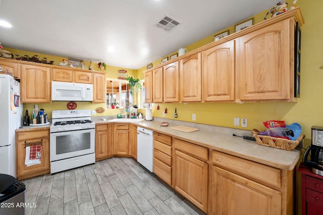 kitchen featuring light countertops, wood finish floors, white appliances, and visible vents