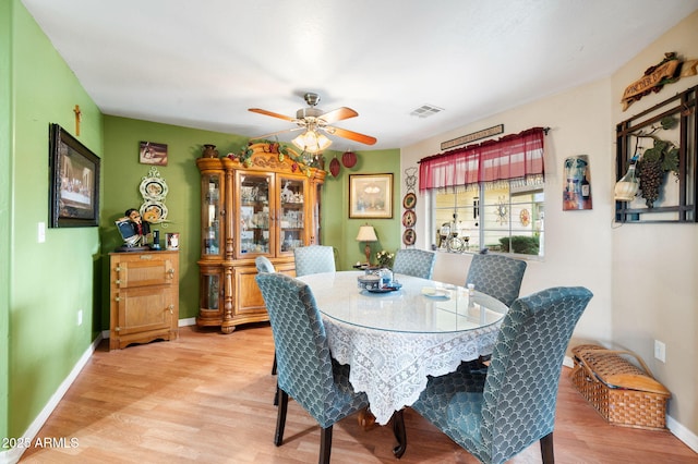 dining space with visible vents, light wood-style flooring, and baseboards