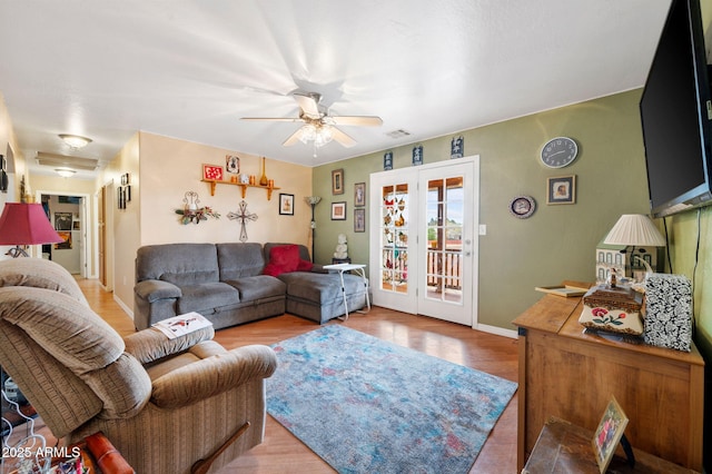 living room featuring ceiling fan, wood finished floors, visible vents, baseboards, and french doors