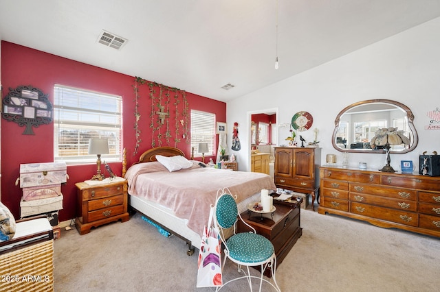 bedroom featuring carpet, visible vents, vaulted ceiling, and ensuite bath