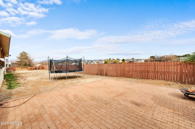view of patio / terrace with a fenced backyard and a trampoline
