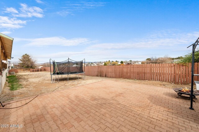 view of patio featuring a trampoline and a fenced backyard