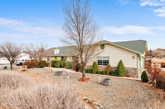 ranch-style home featuring stone siding