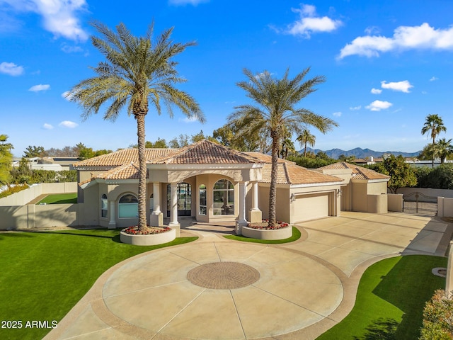 mediterranean / spanish-style house with stucco siding, fence, driveway, a tiled roof, and a front lawn