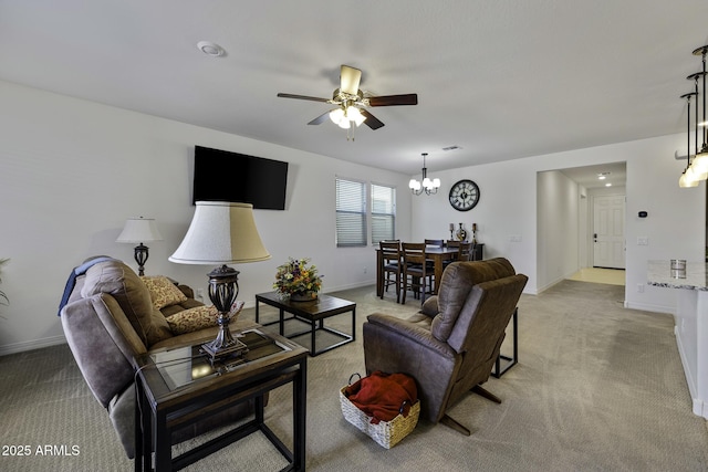 living area featuring light carpet, baseboards, and ceiling fan with notable chandelier