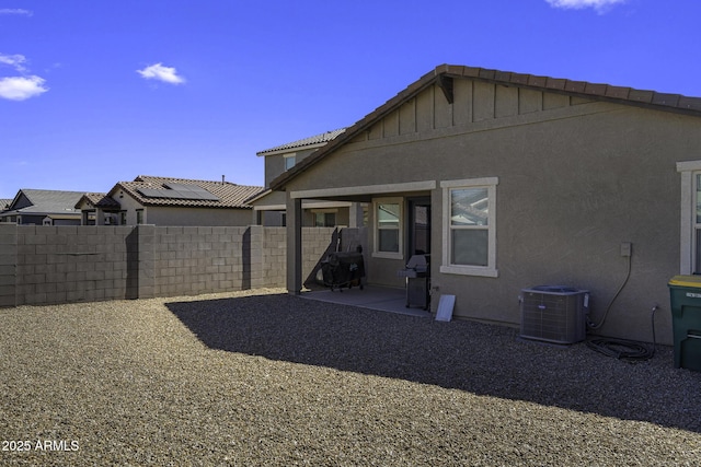 back of house featuring a patio, central AC unit, fence, and stucco siding