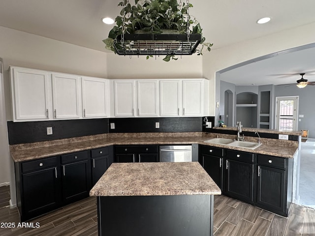 kitchen with kitchen peninsula, sink, a kitchen island, and stainless steel dishwasher