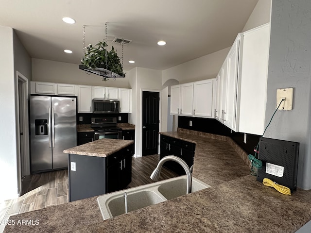 kitchen with sink, a center island, white cabinets, and appliances with stainless steel finishes