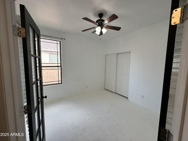 unfurnished bedroom with ceiling fan and a closet