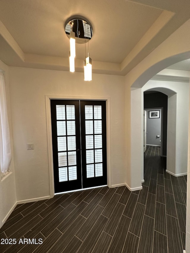 doorway featuring a raised ceiling and french doors