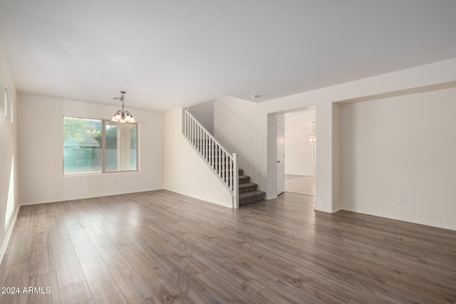 empty room featuring dark hardwood / wood-style floors and an inviting chandelier