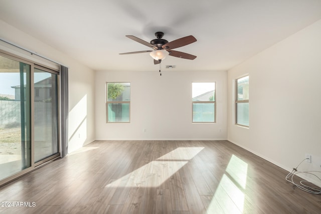 spare room with hardwood / wood-style floors, ceiling fan, and a healthy amount of sunlight