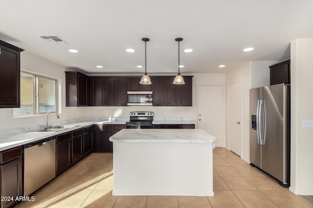 kitchen with a center island, sink, appliances with stainless steel finishes, decorative light fixtures, and light tile patterned flooring