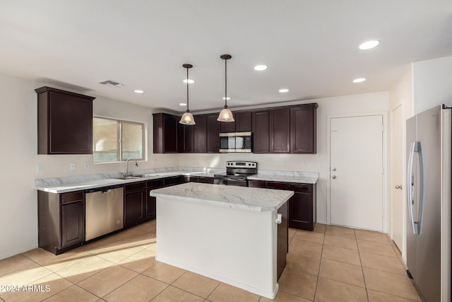 kitchen with a center island, sink, light tile patterned floors, appliances with stainless steel finishes, and decorative light fixtures