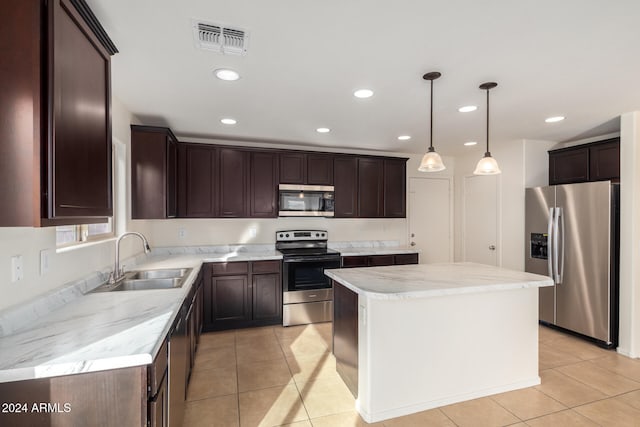 kitchen featuring sink, stainless steel appliances, light tile patterned floors, pendant lighting, and a kitchen island