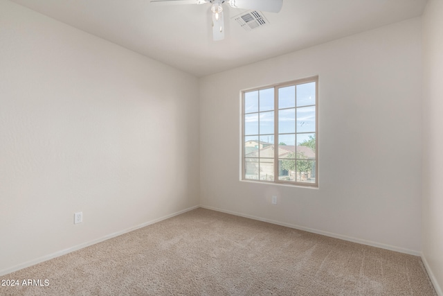 carpeted spare room with ceiling fan