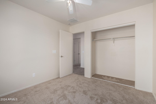 unfurnished bedroom featuring ceiling fan, light colored carpet, and a closet