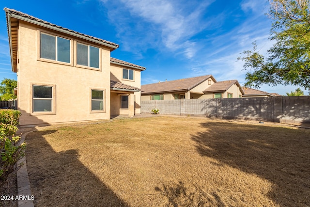 rear view of house featuring a yard