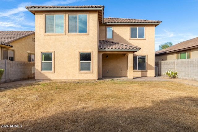 back of house with a yard and a patio