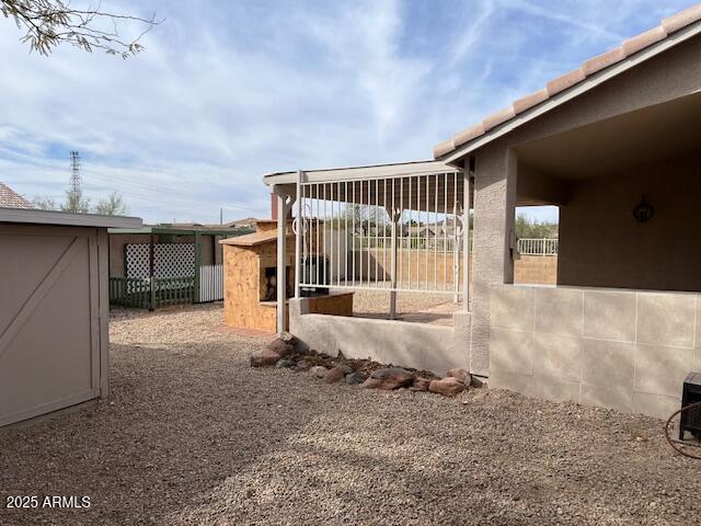 view of side of home featuring an outbuilding and fence