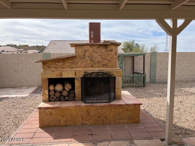 view of patio / terrace with an outdoor fireplace and a fenced backyard