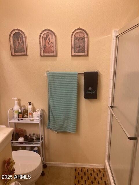 14950 W Mountain View Blvd Unit 5303, Surprise, AZ 85374 - full bathroom featuring a shower stall, toilet, tile patterned flooring, and baseboards